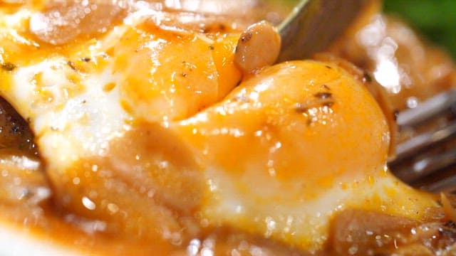 Cutting a hamburger steak with a fried egg and sauce