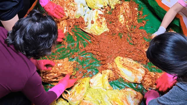 배추와 양념으로 김치 담그는 가족들