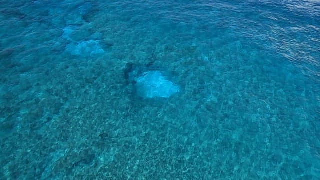 Clear blue ocean water with a person kayaking