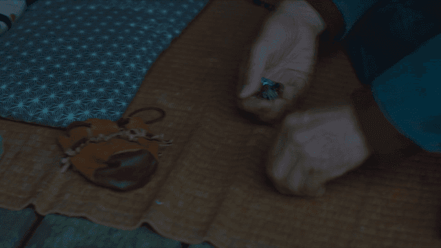 Old man picking up coins on mat