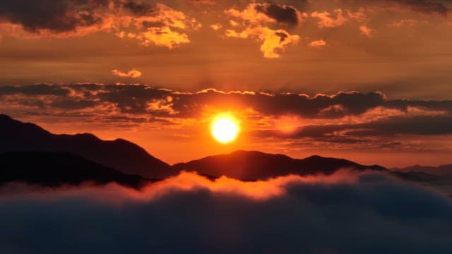 Sunset over mountains with clouds