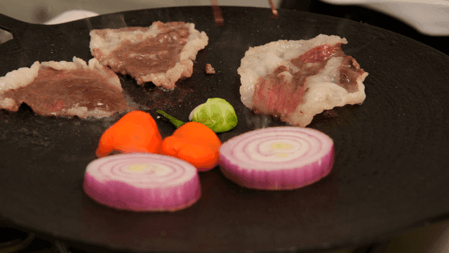 Scene of grilling beef and vegetables on pan