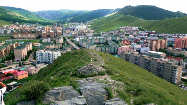 녹색 언덕이 배경인 도시 풍경