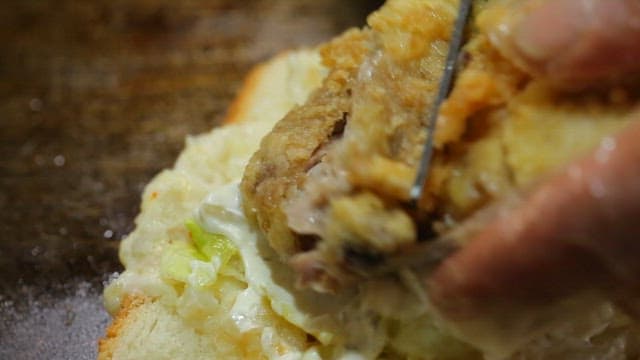 Fried chicken cut with scissors on bread