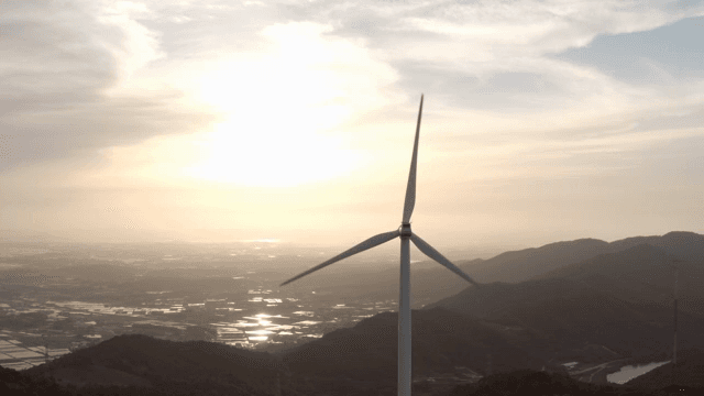 산 위의 풍력 터빈과 일몰