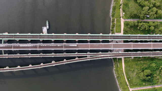Aerial view of bridge over river where train passes.