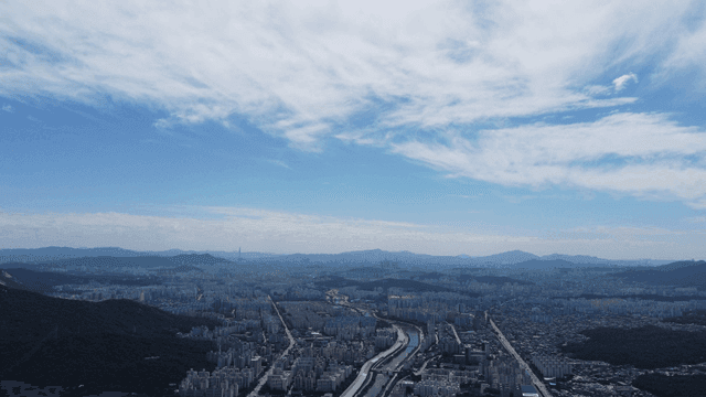 Vast cityscape with mountains visible in distance.