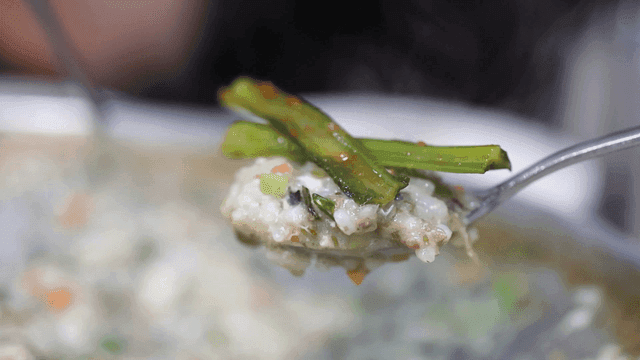Kimchi on spoonful of steaming porridge