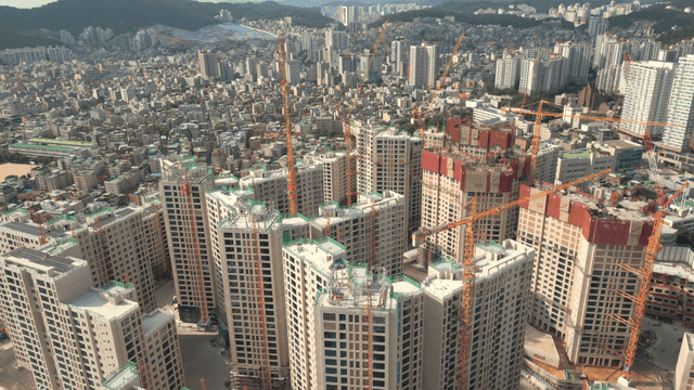 High-rise apartment construction site with cranes connected
