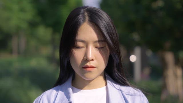 Woman standing in a park in the sunlight