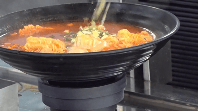 주방에서 로봇이 라면을 요리하는 장면