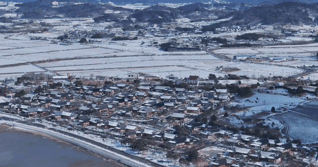 Traditional Hanok village next to snow-covered field