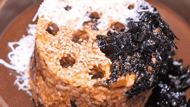 Charcoal-shaped fried rice topped with seaweed and sesame seeds