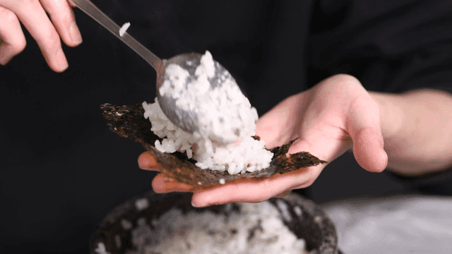 Person who wraps rice in seaweed with their hands