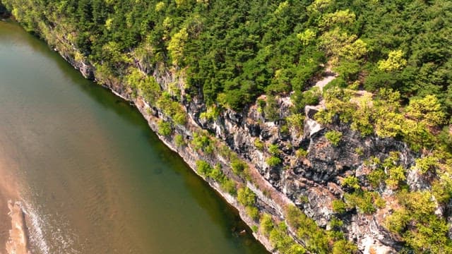 Serene river flowing beside rocky cliffs