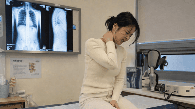Female patient holding her neck
