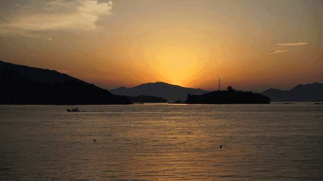 Sunset over a calm sea with mountains