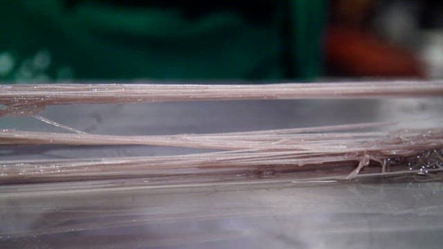 Thin cold buckwheat noodles being prepared on a metal surface