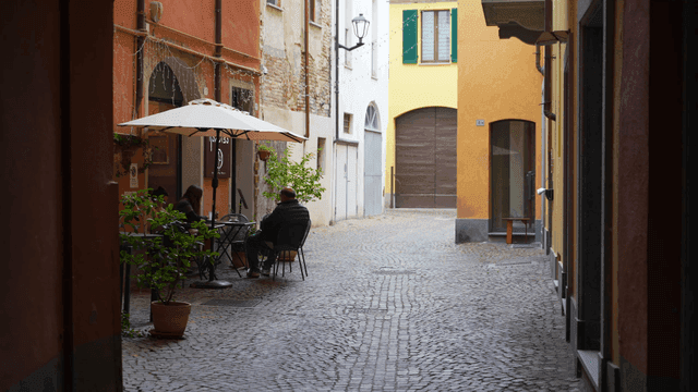 좁은 골목의 야외 카페에서 쉬는 사람들