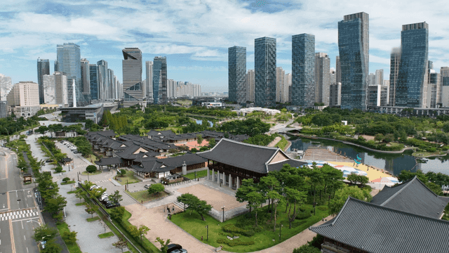Traditional Korean house by the lake with skyscrapers in the background