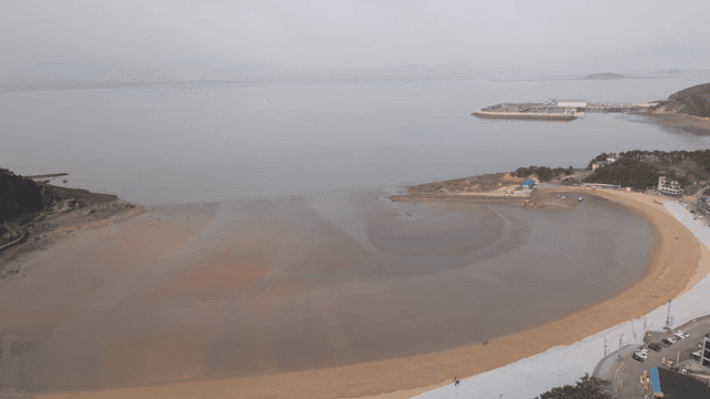 A serene beach with a distant pier