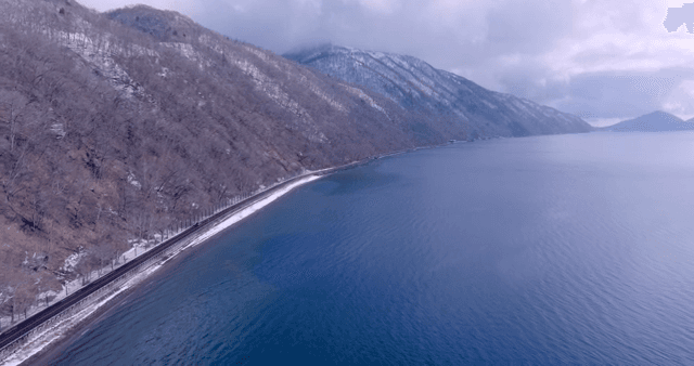 Road along a snowy forest and sea
