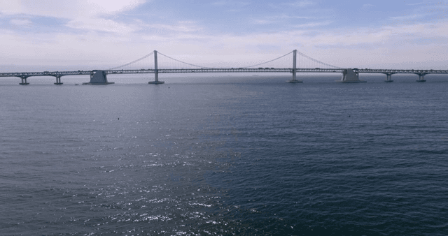 A bridge over a calm sea under a clear sky