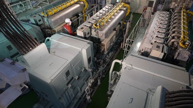 Worker inspecting machinery in an industrial facility