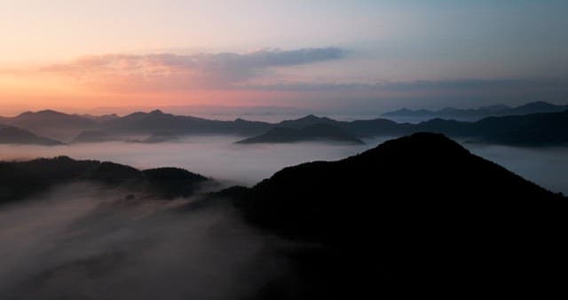 Sky Colored by Sunrise over Foggy Mountains