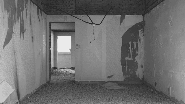 자갈이 깔려있고 벽지가 뜯어져있는 빈 방