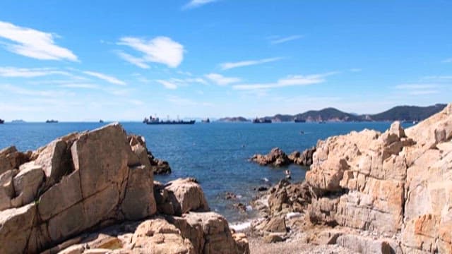 멀리 큰 배가 보이는 바위 해안