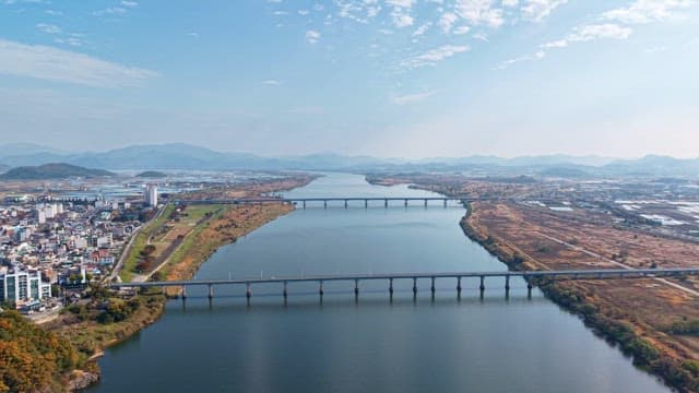 Wide river with a bridge and distant mountains