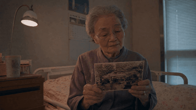 An elderly woman reminiscing with an old photo