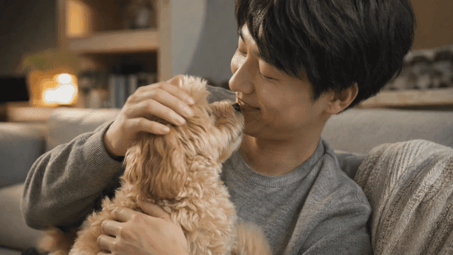 남자가 강아지를 기쁘게 안고 있는 모습