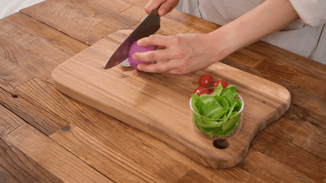 Chopping red onions on wooden cutting board