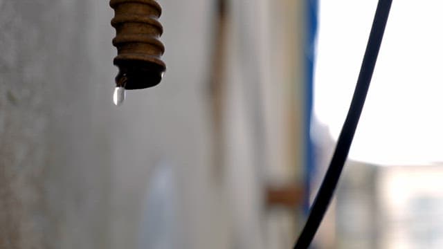 Water drop falling from pipe