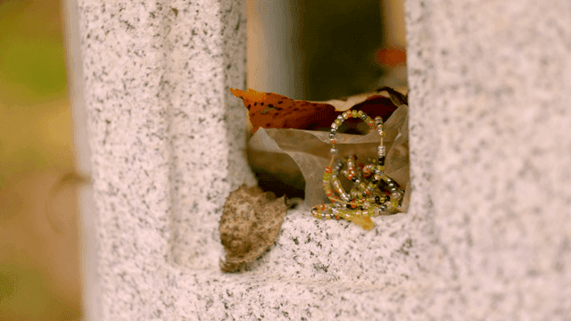 Leaf and bead bracelet on stone surface