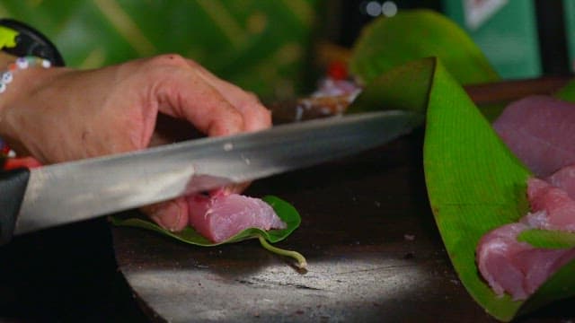 Slicing fresh tuna on a wooden board