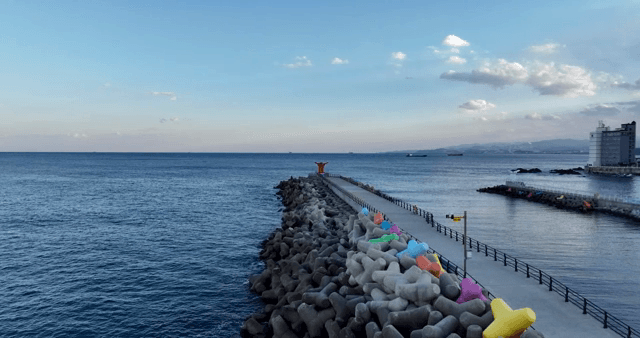 긴 부두와 등대가 있는 해안 마을