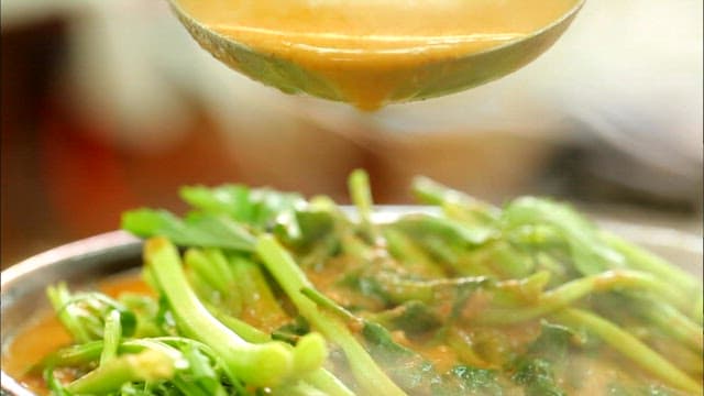 Boiling duck soup topped with water parsley