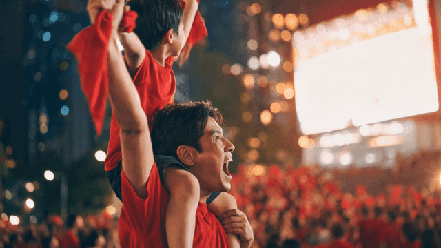 Father and son cheering for night soccer