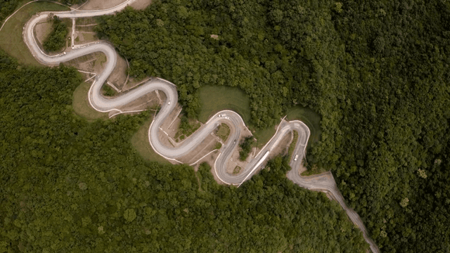 울창한 산 속 구불구불한 도로에서 풍력 터빈 자재를 운반하는 모습