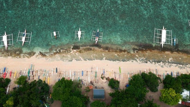 Boats along a clear beach shoreline