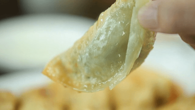 노릇하게 구워진 만두를 집는 모습