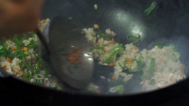 Stir-frying vegetables and rice in a wok