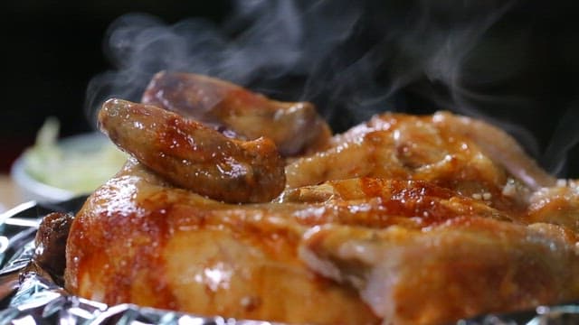 Wood-fired chicken steaming on foil