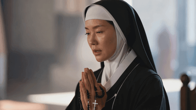 Nun praying with rosary in church