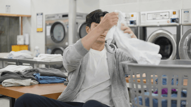 Man doing laundry at coin laundry