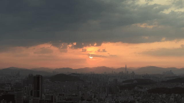 구름이 있는 도시 스카이라인 위의 일출