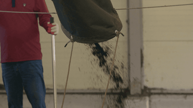 Person pouring fertilizer indoors